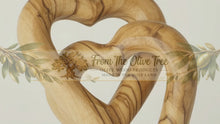 Load and play video in Gallery viewer, Two entwined, hand-carved wooden hearts on a white background. LOVE4EVER
