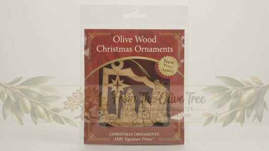 A wooden hanging Christmas decoration depicting the nativity scene with the 3 Kings giving their gifts to baby Jesus.
